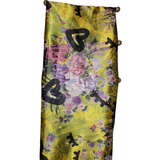 Floral patterned fabric with black heart shapes on a yellow background