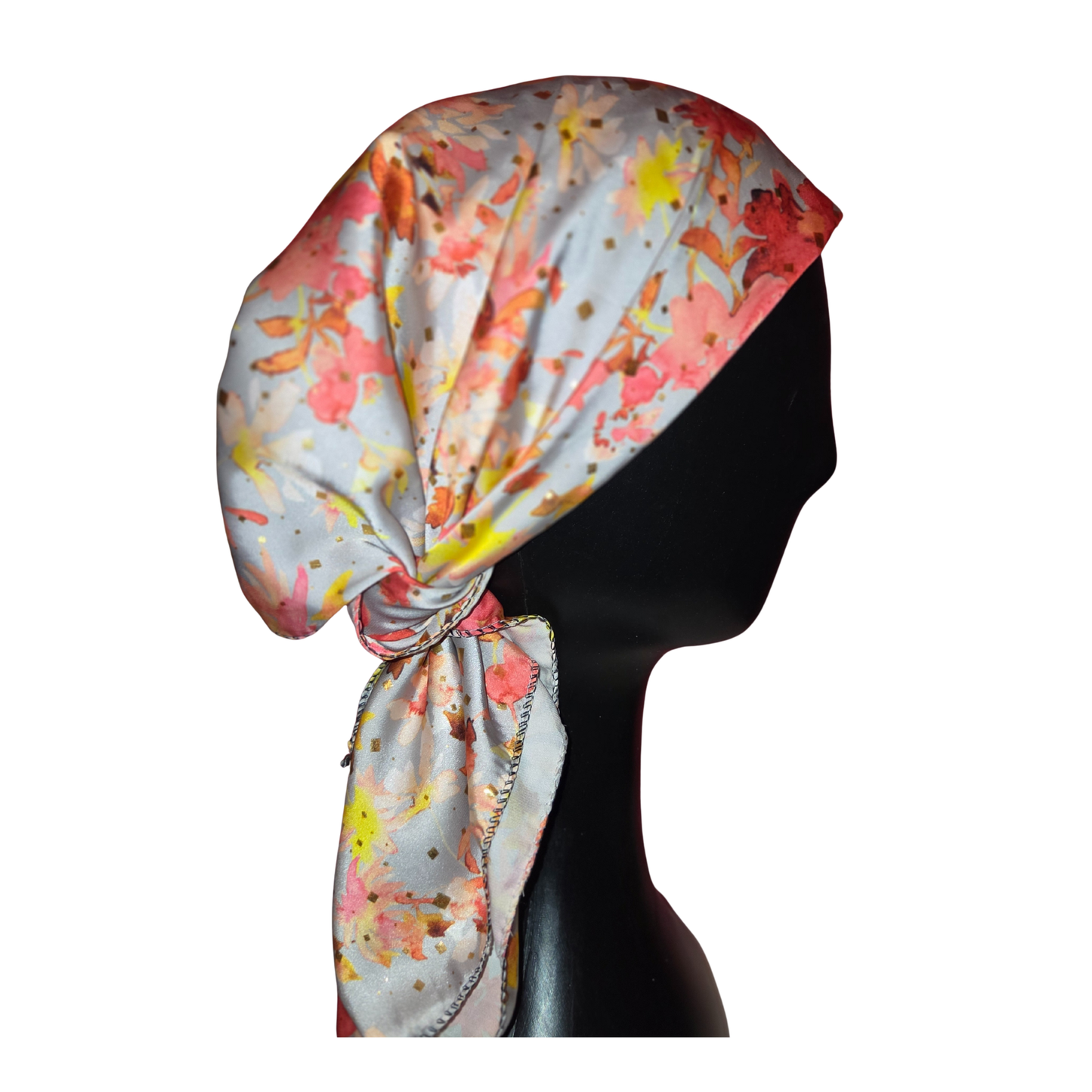 Colorful headscarf with floral pattern on a mannequin head against a white background
