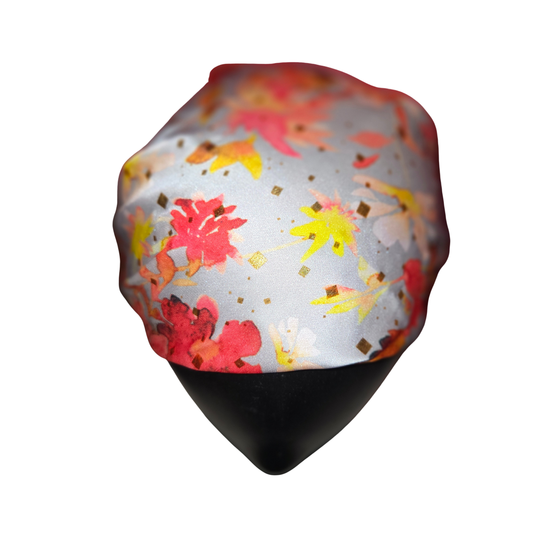 Colorful floral-patterned headscarf on a mannequin head against a white background