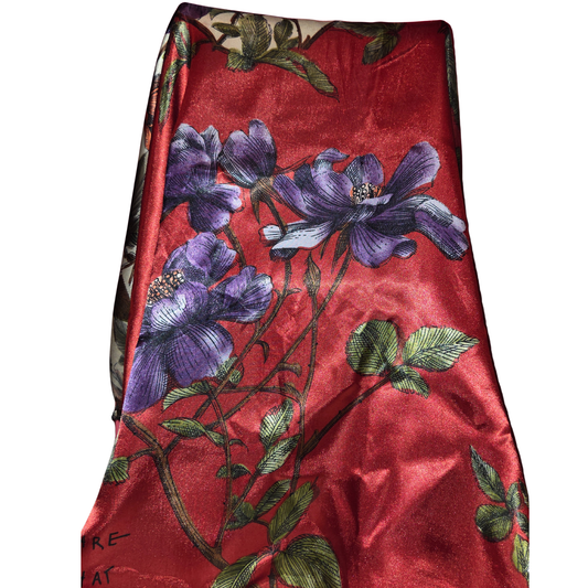 Red fabric with purple floral embroidery on a white background
