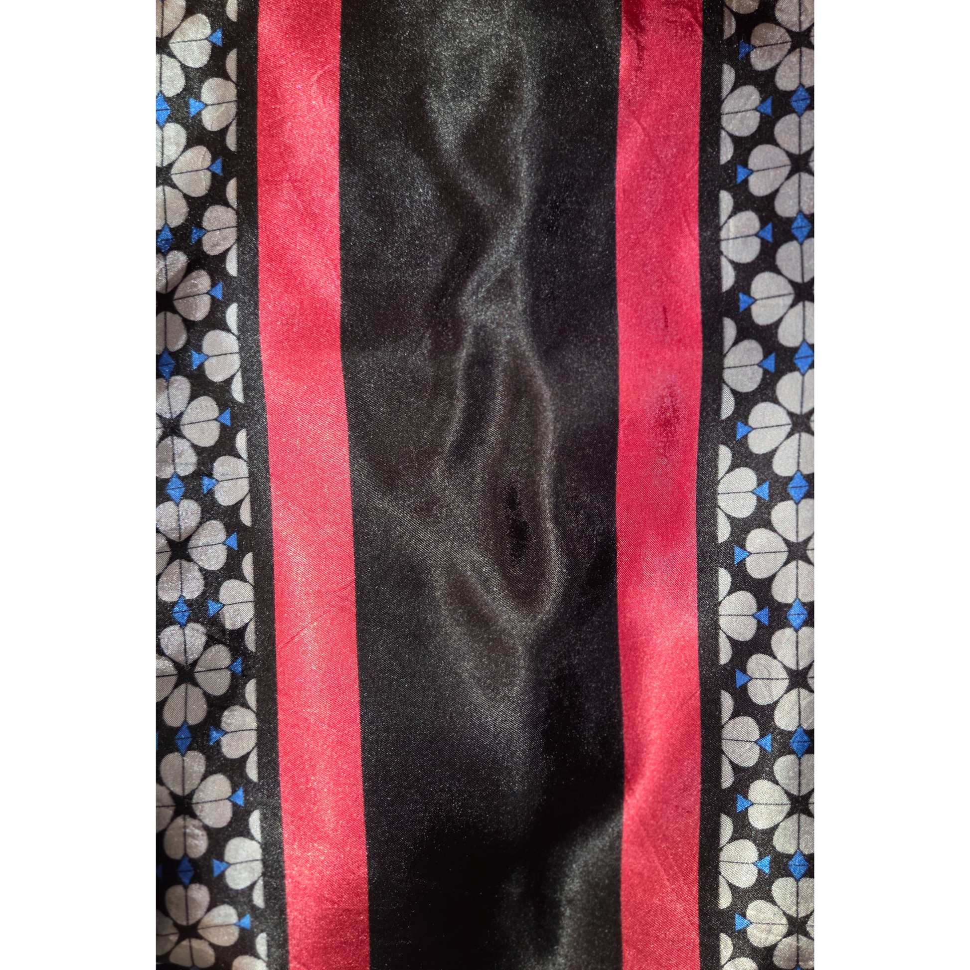 Close-up of a fabric with red stripes and floral patterns on a black background