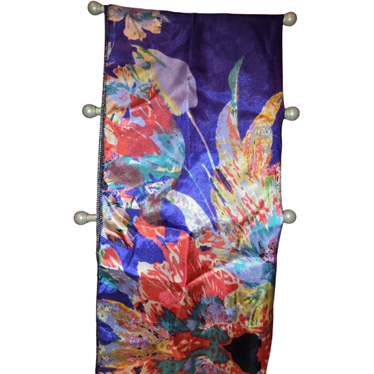 Colorful floral patterned fabric hanging on a rod with a white background