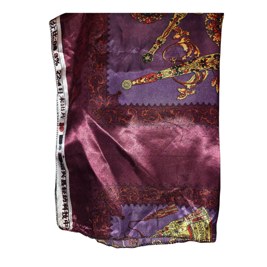 Purple fabric with intricate gold and multicolor designs on a white background