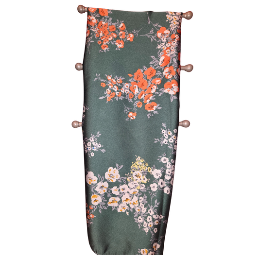 Floral-patterned fabric on a green background with wooden hangers.